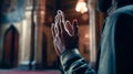 Hand of stands muslim man praying with mosque interior background