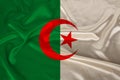 Photo of the national flag of algeria on a luxurious texture of satin, silk with waves, folds and highlights, closeup, copy space Royalty Free Stock Photo