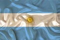 Photo of the national flag of Argentina on a luxurious texture of satin, silk with waves, folds and highlights, close-up, copy