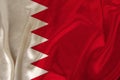 Photo of the national flag of Bahrain state on a luxurious texture of satin, silk with waves, folds and highlights, close-up, copy
