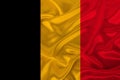 Photo of the national flag of Belgium on a luxurious texture of satin, silk with waves, folds and highlights, close-up, copy space Royalty Free Stock Photo