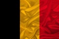 Photo of the national flag of Belgium on a luxurious texture of satin, silk with waves, folds and highlights, close-up, copy space