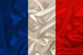 Photo of the national flag of France on a luxurious texture of satin, silk with waves, folds and highlights, closeup, copy space,