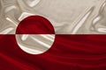 Photo of the national flag of Greenland on a luxurious texture of satin, silk with waves, folds and highlights, close-up, copy