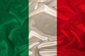 Photo of the national flag of Italy on a luxurious texture of satin, silk with waves, folds and highlights, close-up, copy space, Royalty Free Stock Photo