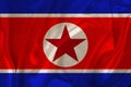 Photo of the national flag of north korea on a luxurious texture of satin, silk with waves, folds and highlights, close-up, copy