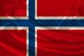Photo of the national flag of Norway on a luxurious texture of satin, silk with waves, folds and highlights, close-up, copy space