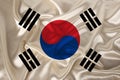Photo of the national flag of South Korea on a luxurious texture of satin, silk with waves, folds and highlights, close-up, copy Royalty Free Stock Photo