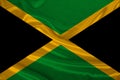 Photo of the national flag of the state of Jamaica on a luxurious texture of satin, silk with waves, folds and highlights, close- Royalty Free Stock Photo