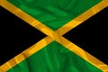 Photo of the national flag of the state of Jamaica on a luxurious texture of satin, silk with waves, folds and highlights, close- Royalty Free Stock Photo