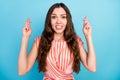 Photo of nervous anxious troubled lady crossed fingers pray wear striped dress isolated blue color background