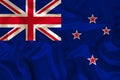 Photo of the New Zealand state national flag on a luxurious texture of satin, silk with waves, folds and highlights, close-up,