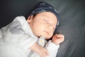 Newborn baby sleeping on gray bedspread on bed. Happy motherhood concept, adoption