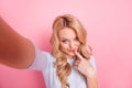 Photo of nice adorable girl make selfie finger touch lips isolated on pastel pink color background Royalty Free Stock Photo