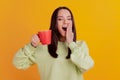 Photo of nice attractive girl holding in hands cup drinking latte morning yawn  on yellow color background Royalty Free Stock Photo