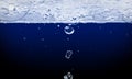 Photo of water trickle and drops on dark blue background