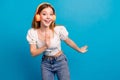 Photo of nice young girl headphones dance empty space wear top isolated on blue color background