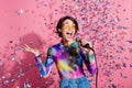 Photo of nice young woman sing microphone confetti wear pullover  on pink color background Royalty Free Stock Photo