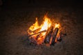 Photo of a night bonfire against a dark background. Flames scatter sparks in all directions. Brightly burning orange Royalty Free Stock Photo