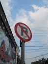 Photo of no parking sign near wall with graffiti