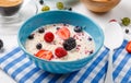 Photo of oatmeal with strawberries, raspberries, blackberries on plaid napkin