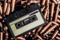 Photo of an old audio tape cassette on pile of bullets Royalty Free Stock Photo