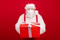 Photo of old bearded merry santa worker distance work take clients order big gift box delivery home holiday wear protect Royalty Free Stock Photo