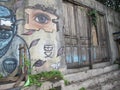 Photo of an old door in an abandoned building with a wall decorated with graffiti