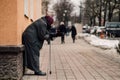 Photo of old hungry homeless female beggar beg for alms and on street.