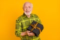 Photo of old man grandfather happy positive smile hold gift present box holiday celebrate isolated over yellow color