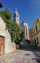 Photo of the old narrow cobblestone (natural stone) streets of medieval European small town, going to an ancient Catholic Church.