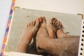 Photo of an old photograph of young couple feet on the beach