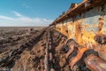 A photo of an old, rusty plowing machine with metal chains and wooden structures lying on the ground in front of it. the back Royalty Free Stock Photo