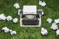 Photo of old typewriter on a green grass with a sheet of paper. Royalty Free Stock Photo
