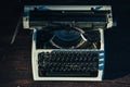 Photo of old typewriter on wooden table in sunset light, retro look. Royalty Free Stock Photo