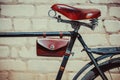 Photo old vintage bike, which stands near the brick wall. Close up of an old, worn-out bicycle frame in which leather,