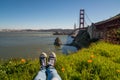 Photo of one`s feet in the park on a sunny day by the Golden Gate Bridge in San Francisco