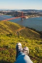 Photo of one`s feet in the park on a sunny day by the Golden Gate Bridge in San Francisco