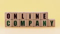 Photo on online company theme. wooden cubes with the words `online company`, on light yellow background