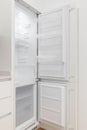 Photo of an open, empty and white refrigerator in a modern kitchen Royalty Free Stock Photo