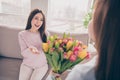 Photo of optimistic brunette red hairdo mom daughter gift flower sit on sofa wear sweater at home