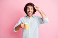 Photo of optimistic cheerful brown hair guy hold cup take off spectacles blue shirt isolated on pastel pink color