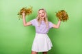 Photo of optimistic girl curly hairdo wear striped t-shirt dancing with cheerleading poms having fun isolated on green