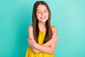 Photo of optimistic nice brown hair girl hug herself wear yellow dress isolated on bright teal color background