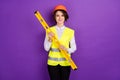 Photo of optimistic nice brunette hair lady hold tool wear builder uniform isolated on purple color background Royalty Free Stock Photo