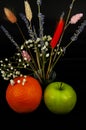 Art photo orange with apple and a bouquet of lavender flowers and others on a black background