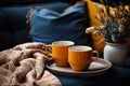 Photo of an orange coffee cup atop a couch, image of coffee cup