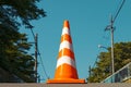 Photo Orange and white street cone against natural background, caution symbol