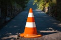 Photo Orange and white street cone against natural background, caution symbol