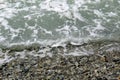 Photo out of focus. Wave sea. Water splash on the shore with a pebble beach. Royalty Free Stock Photo